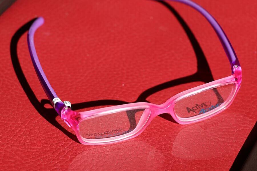 Pinkfarbene Kinderbrille mit lila Bügeln