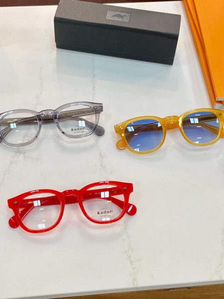 Rote und gelbe Brille sowie eine in hellem Grau - eyewear auf der Optikermesse Opti
