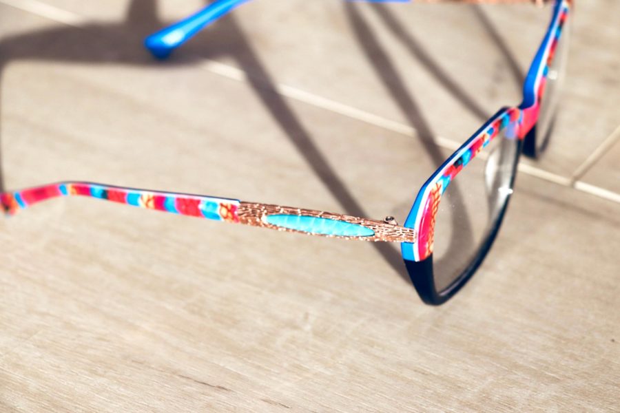 Seitlicher Blick auf eine schwarzgrundige Brille aus der La-Matta-Kollektion mit Pink-blauem Muster oberhalb der Brillengläser