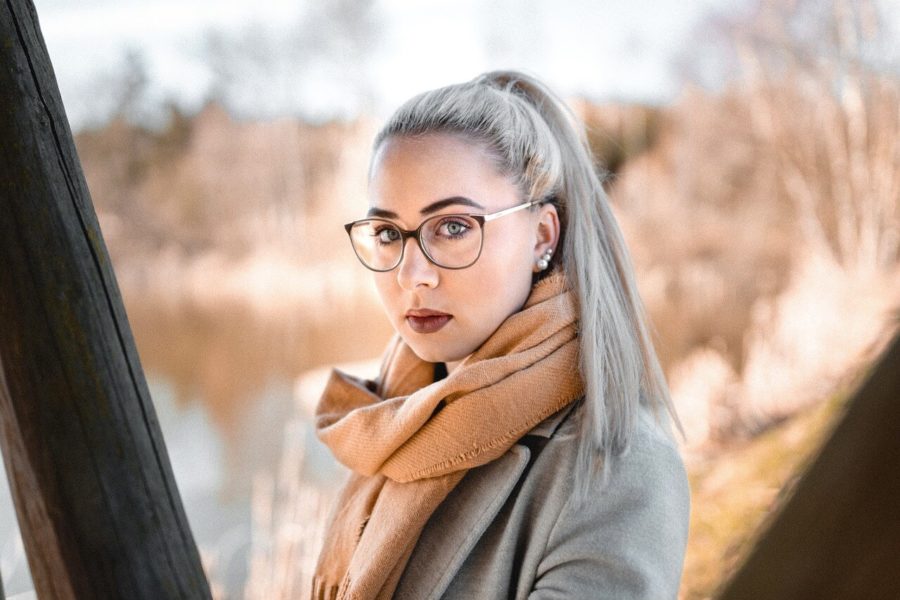 Frau mit blonden Haaren zum Zopf gebunden, die die perfekte Brille auf der Nase hat. 