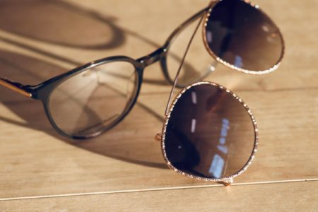 Brillen mit Sonnenclips sind gute Alternativen zu Ray Ban-Sonnenbrillen - zu sehen ist eine Brille mit schräg davor liegendem Sonnenclip