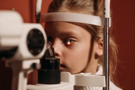 Augenuntersuchung für die Vermeidung von Augenerkrankung - es ist ein junger Mensch zu sehen, bei dem ein Auge mit einem speziellen Gerät mit einem Lichtstrahl untersucht wird