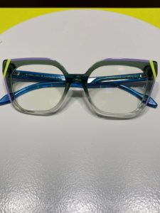 Brillentrends 2024 - Neongelbe Streifen auf grauen Farbübergängen von dunkel zu hell sind das Markenzeichen diesere Brille von Res/Rei