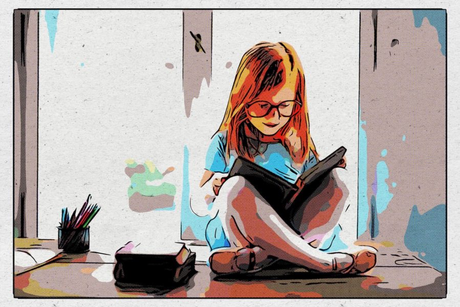 Ein Mädchen mit Brille sitzt auf einem Schreibtisch und liest.
