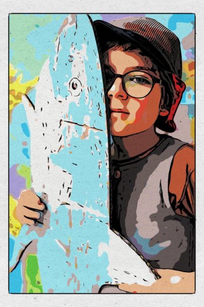 Ein Junge mit Brille hält ein Haifisch-Surfbrett in der Hand. Das Foto illustriert das Thema: Kurzsichtigkeit bei Kindern verbessern
