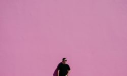 Mann im schwarzen Shirt vor rosa Wand - Optik Westermeier