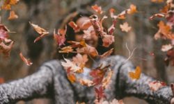 woman throwing maple leaves
