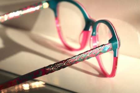 Brille in hellblau und pink mit goldfarbenen Applikationen an der Vorderseite oben