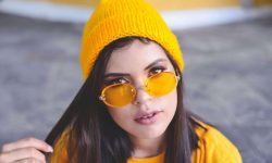 Bunte Brillen setzen Statements - Frau mit orangefarbiger Brille und orangener Mütze