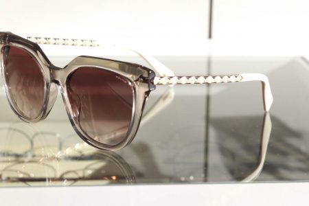 Katzenaugenbrille mit dunklen Gläsern und weißen Bügeln mit Muster von Police