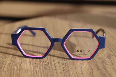 Sechseckige Moloka-Brille mit rosafarbenen Akzent am Rahmen. Zu haben bei Optik-Westermeier 